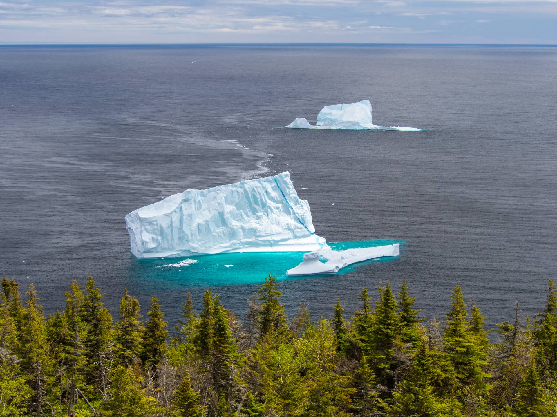 A large iceberg floating in the ocean under a clear sky